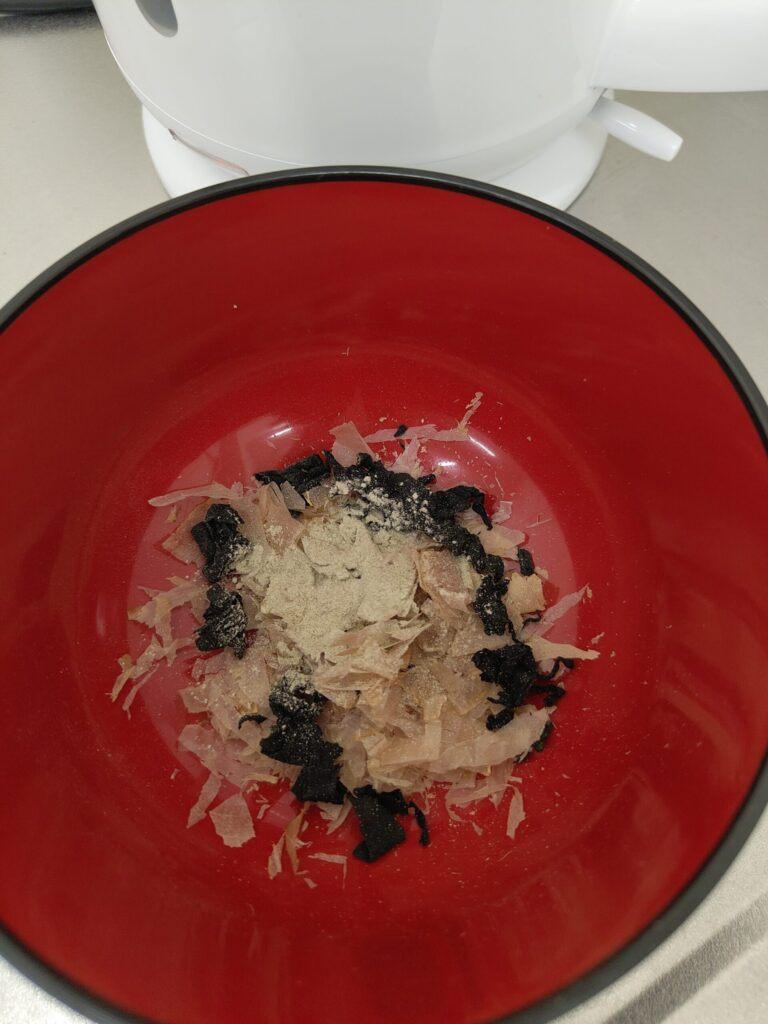 味噌汁に乾燥わかめと花かつおと粉末昆布を入れて出汁を取る準備